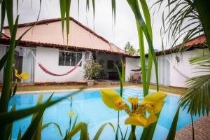 a villa with a swimming pool in front of a house at Sertões Hospedaria & Cultura in Carolina