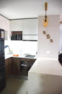 a kitchen with white cabinets and a white counter top at The Fox Departamentos in Santiago