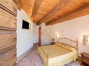 a bedroom with a bed and a wooden ceiling at Belvilla by OYO La Priora in Monte San Martino