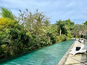 a swimming pool with lounge chairs in a resort at Kebun Villas & Resort in Senggigi