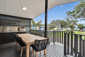 a dining room table with chairs and a fence at Ingenia Holidays Lake Macquarie in Mannering Park