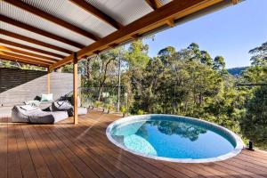 an outdoor patio with a large pool on a wooden deck at Pool House Bellingen in Fernmount