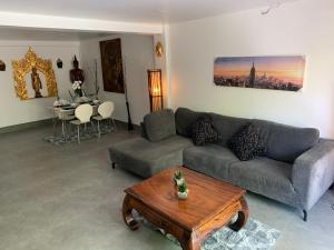 a living room with a couch and a table at Fong Kaew and Baan Nang Fa Guesthouse in Patong Beach