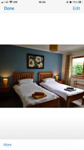 a bedroom with two beds and a window at Brackenbrae Holiday Cottage in Acharacle