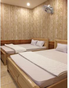 Habitación con 3 camas en una habitación en Nhà Nghỉ Nguyên Anh, en Long Hai