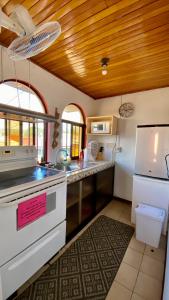 a kitchen with a white stove and a refrigerator at Apartment 10 minutes by the SJO airport - in Alajuela