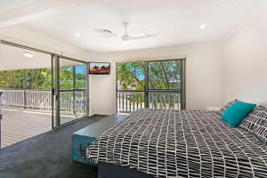サンシャインビーチにあるDepper St Beautifully Renovated Beach Houseの大きなベッドとバルコニーのある寝室