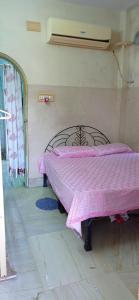 1 dormitorio con 1 cama con manta rosa en Peaceful Living en Calcuta