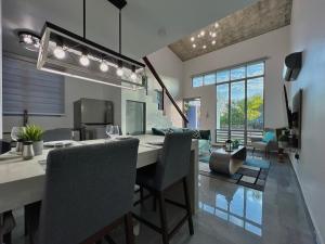 a dining room and living room with a table and chairs at Sunset Coast Loft & Rooftop in Aguacate