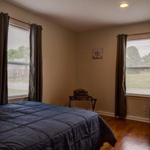 a bedroom with a bed and two large windows at Winner's Getaway in Norwich