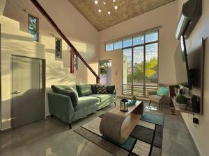 a living room with a couch and a tv at Sunset Coast Loft & Rooftop in Aguacate