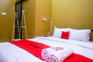 a bedroom with two beds with red and white towels at RedDoorz Syariah near Exit Toll Ngemplak Solo in Sawahan