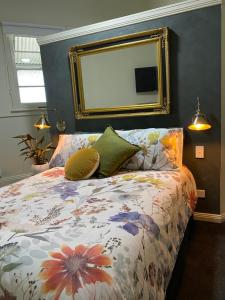 una camera da letto con un letto con un grande specchio sul muro di Wingham House a Wingham