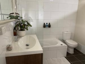 bagno bianco con lavandino e servizi igienici di Wingham House a Wingham