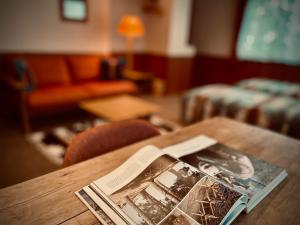 a magazine sitting on a wooden table in a living room at Okushiga Lodge Yama no Manimani in Yamanouchi