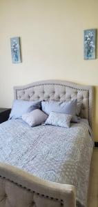 a large bed with pillows on it in a bedroom at Hillside Sunrise, 2 Bed 2 Bath in Gated Community, close to beach, food, clubs & shopping Free Parking, Free Wi-Fi in Montego Bay