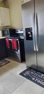 a kitchen with a stainless steel refrigerator and an oven at Hillside Sunrise, 2 Bed 2 Bath in Gated Community, close to beach, food, clubs & shopping Free Parking, Free Wi-Fi in Montego Bay