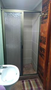 a shower with a glass door next to a sink at sleep easy 2 in Coquimbo