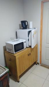 a microwave and other appliances on top of a wooden stand at sleep easy 2 in Coquimbo