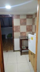 eine kleine Küche mit einem Tisch und einem Kühlschrank in der Unterkunft sleep easy 2 in Coquimbo