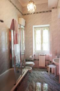 a bathroom with a tub and a toilet and a sink at Villa Quaranta in Portici