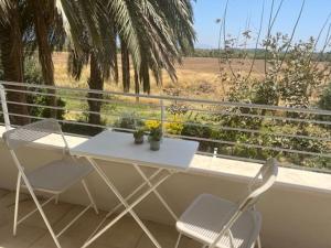 einen weißen Tisch und zwei Stühle auf dem Balkon in der Unterkunft שדות וים in Schawe Zion