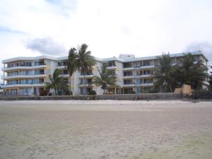 a large building on the beach with palm trees at Baan Plerd Plern by Golf in Hua Hin
