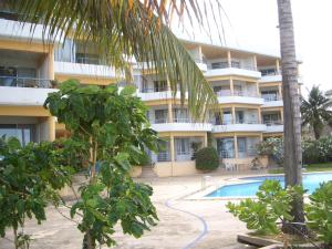a hotel with a swimming pool in front of a building at Baan Plerd Plern by Golf in Hua Hin