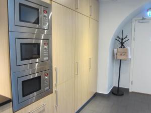 a kitchen with two microwave ovens on a wall at Hostel Dalagatan in Stockholm
