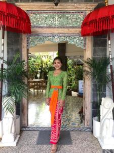 a woman standing in front of a building at Su's Cottages Legian in Legian