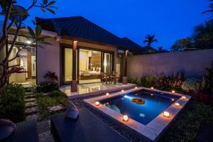 a swimming pool in the backyard of a villa at night at Villa Mandi Ubud in Ubud