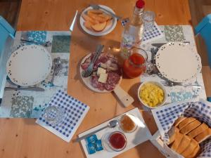 a wooden table with plates of food on it at Camere Nordest Sudest- Conca Agordina in Agordo