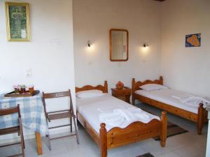 two beds in a room with a table and chairs at Diamanti Molivos Studios & Apartments in Mithymna