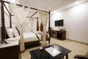 a hotel room with a bed and a desk and a tv at Once Upon The River, Aluva - Near Cochin International Airport in Cochin