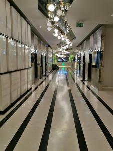 a hallway in a building with black and white floors at Orbi beach tower in Batumi