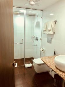 uma casa de banho com um chuveiro, um WC e um lavatório. em The Neem em Nova Deli