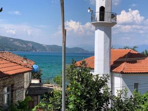 a lighthouse in the middle of a town next to the water at Vila Du Lac Blue in Pogradec