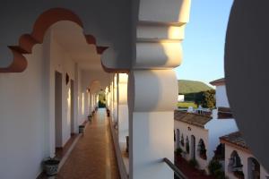 an alley in a building with white walls and a hallway at Hostal Alhambra in Zahora