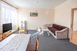 un soggiorno con un divano e un tavolo di Apartmány Domek u lesa a Bítov
