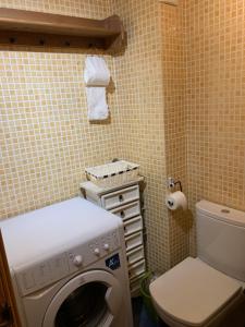 uma casa de banho com uma máquina de lavar roupa e um WC em Apartament Orbis La molina em La Molina