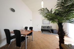 a dining room with a table and a palm tree at Apartment-Josip in Vir