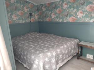 um quarto com uma cama com flores na parede em SkillHill em Muuruvesi