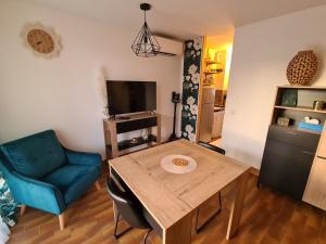 ein Wohnzimmer mit einem Holztisch und einem blauen Stuhl in der Unterkunft Studio avec terasse vue mer in Porticcio