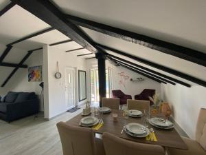 a dining table and chairs in a living room at Apartmani Grebastica in Grebaštica