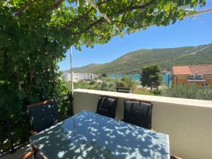 a table and chairs on a balcony with a view at Apartmani Grebastica in Grebaštica