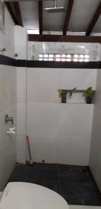 a bathroom with a toilet and a plant on the wall at Benara Shariah Homestay in Yogyakarta