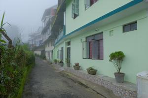 a street with white buildings and potted plants at Down Town Homestay in Kurseong