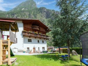 a house with a playground in front of a mountain at Cozy Holiday Home in Tyrol near Ski Area in Oetz