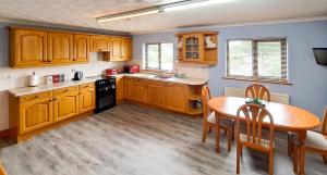 a kitchen with wooden cabinets and a table and a dining room at Gretna Getaway in Gretna
