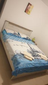 een bed met een blauw en wit dekbed erop bij Apartment Bradex Dreams in Becici